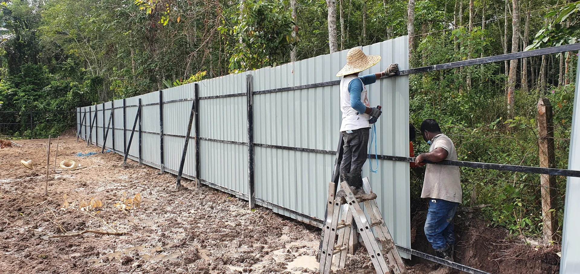 Crew fixing metal cladding to the frame