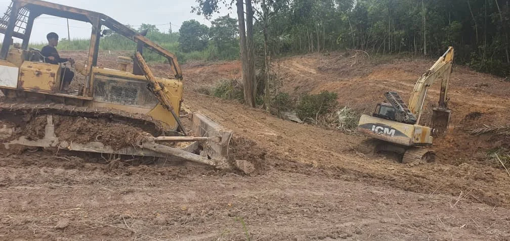 Bulldozer and excavator shaping the platform on cleared land